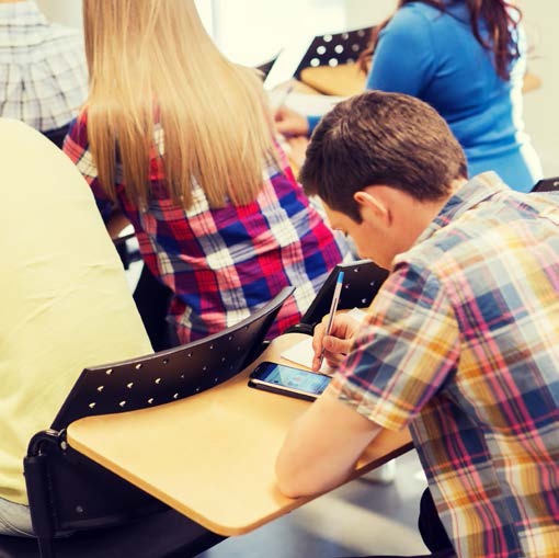 Description de l'image par IA : Un adolescent en fauteuil roulant utilise un smartphone dans un cadre scolaire.