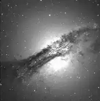 Description de l'image par IA : Galaxie NGC 5128 avec une structure sombre et lumineuse, entourée d'étoiles brillantes.
