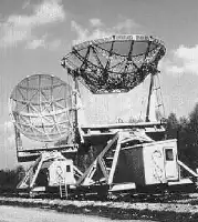 Description de l'image par IA : Deux grandes antennes radar allemandes sur une voie ferrée, photographiées dans les années 1960 à Nançay.