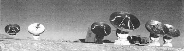 Description de l'image par IA : Six antennes paraboliques mobiles de 15 mètres de diamètre sur terrain sablonneux.