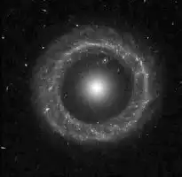 Description de l'image par IA : Nebuleuse circulaire brillante au centre, entourée d'un anneau dense de matière lumineuse.