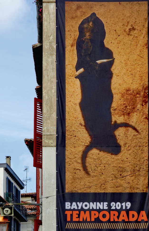 Description de l'image par IA : Bannière avec ombre de personne tenant un couteau, texte "BAYONNE 2019 TEMPORADA".