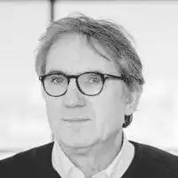 Description de l'image par IA : Homme âgé portant des lunettes et une veste sombre, en noir et blanc.