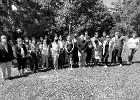 Description de l'image par IA : Groupe de personnes debout dans un parc, en noir et blanc, sous des arbres.