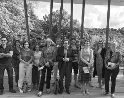 Description de l'image par IA : Groupe de personnes posant ensemble en extérieur, certains tenant des livres.