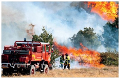 Description de l'image par IA : Camion de pompiers lutte contre un incendie dans un champ.
